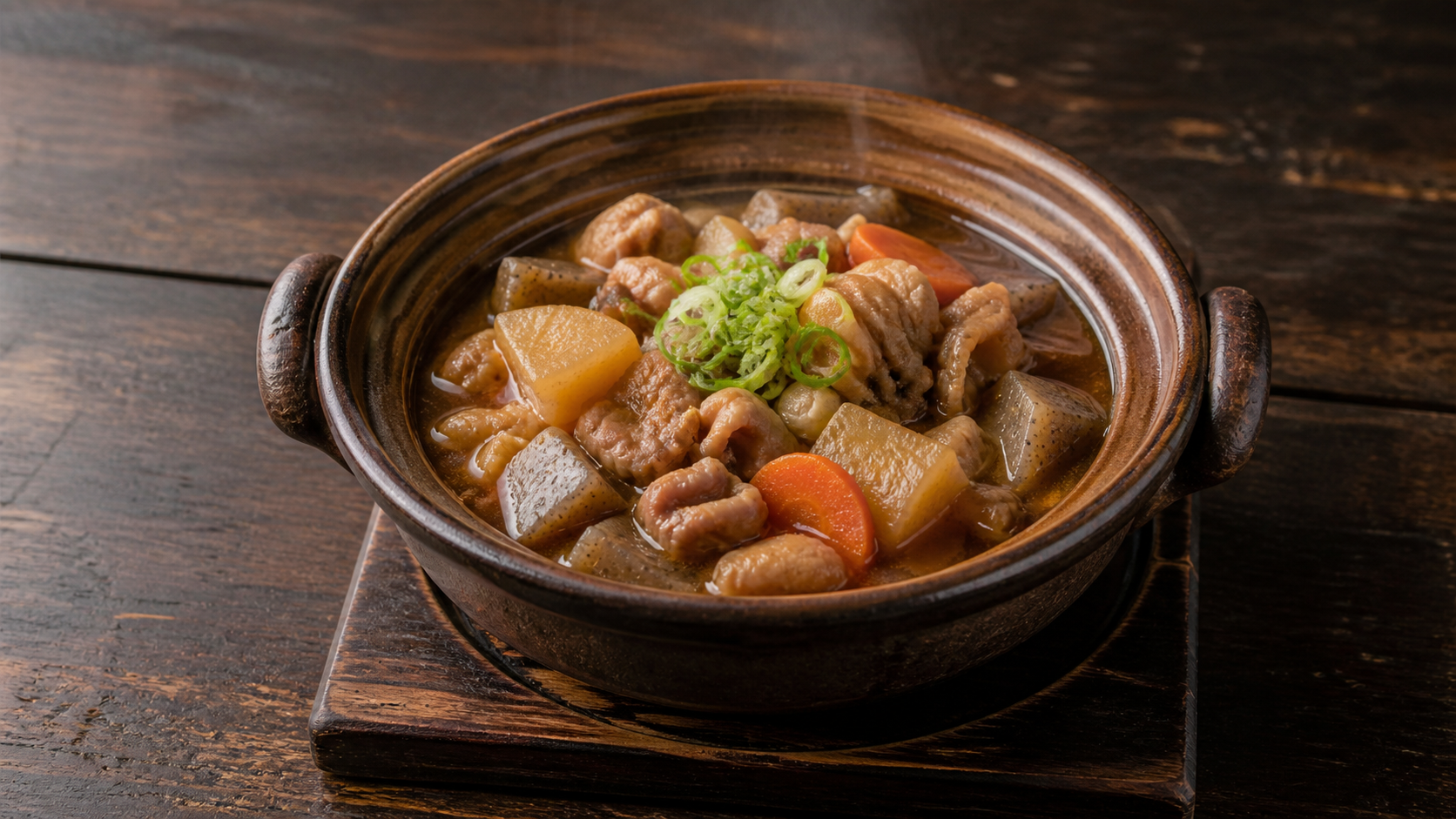 茶色の土鍋に大根とこんにゃくを入れたもつ煮込みのAI生成イメージ