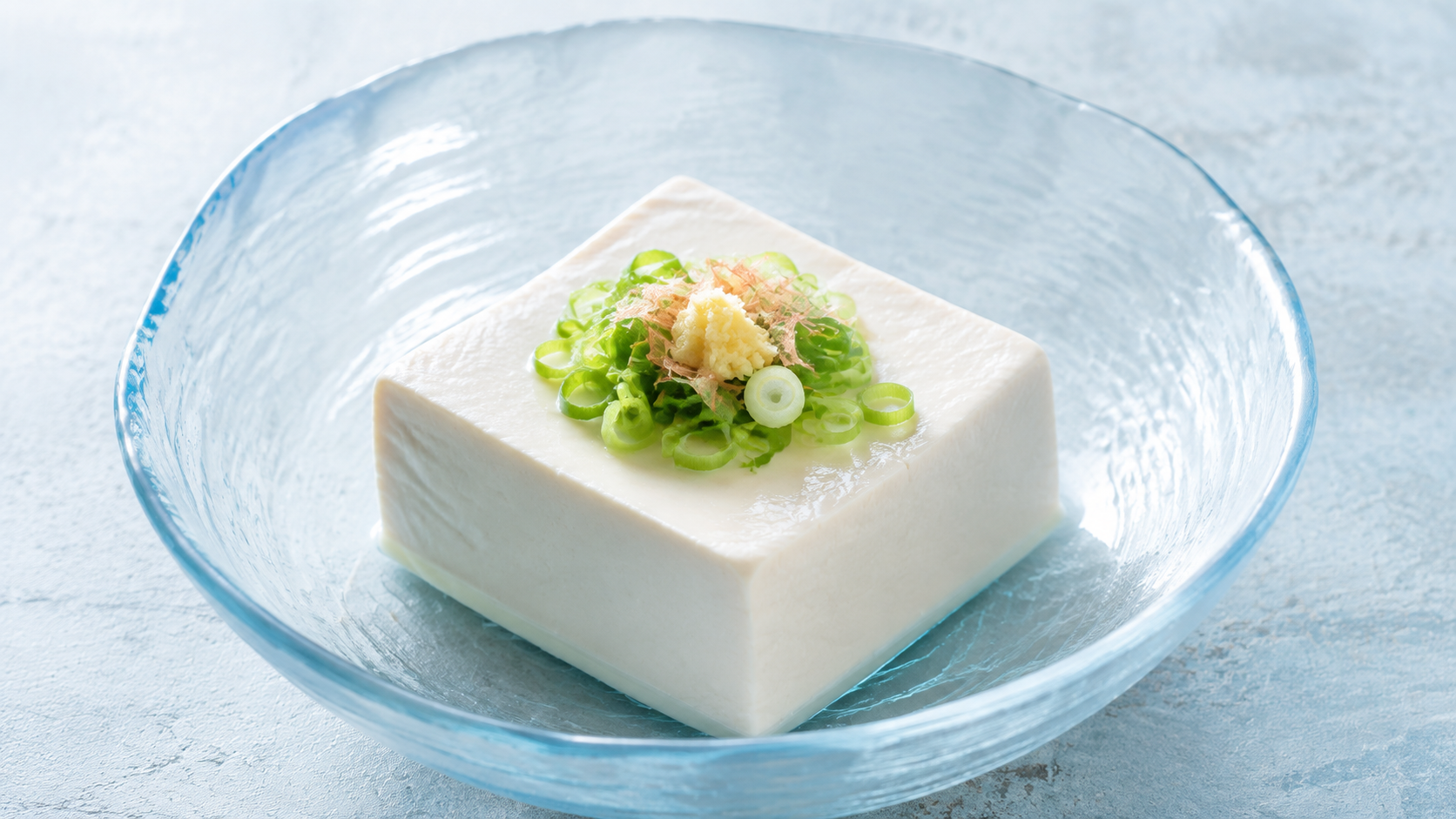 薄青い器の冷奴にねぎと生姜とかつお節を添えたAI生成イメージ