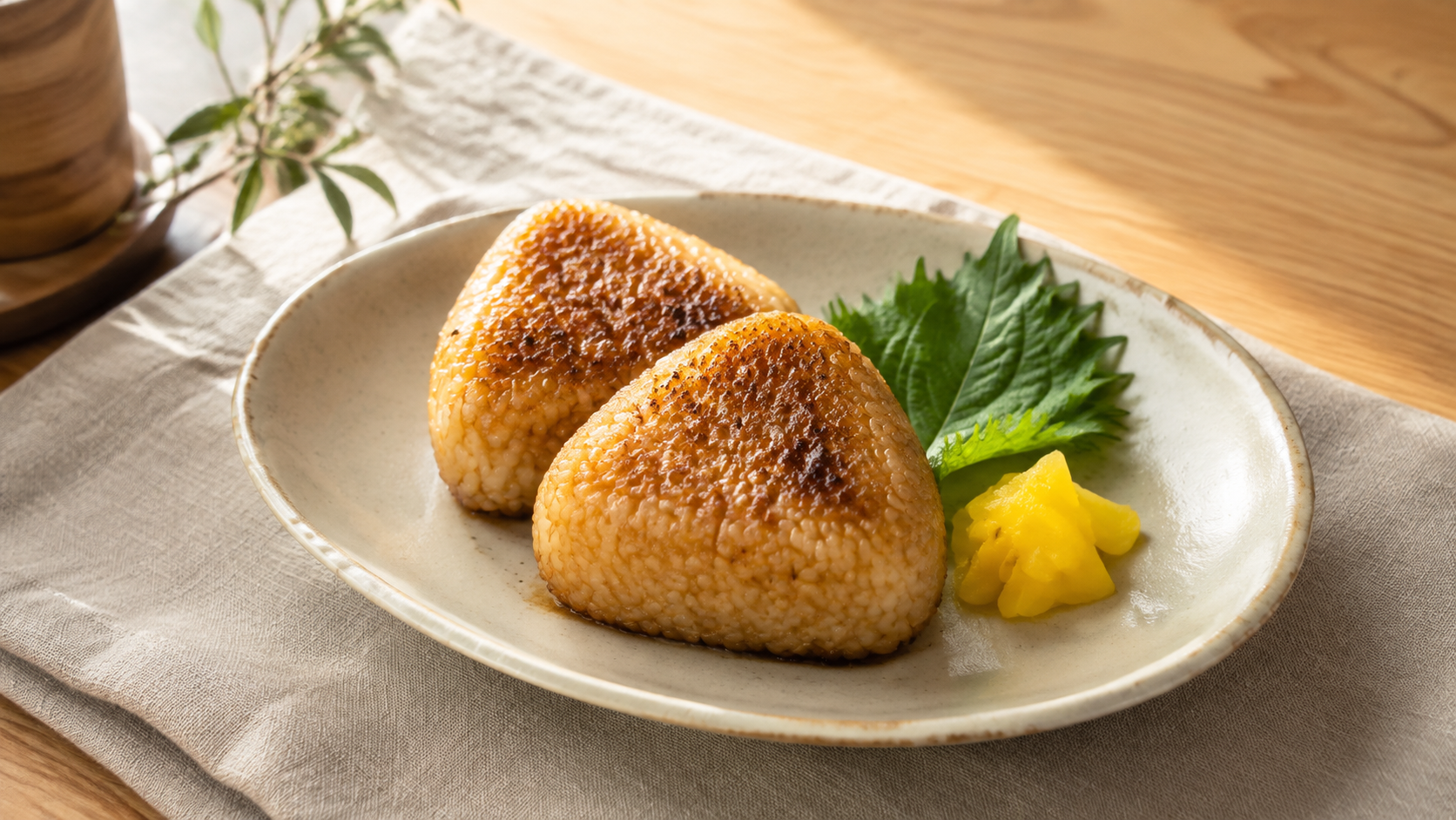 白い陶器に二つの焼きおにぎりと漬物を盛ったAI生成イメージ